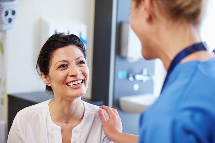 Female Patient Being Reassured By Doctor In Hospital Room - stock photo